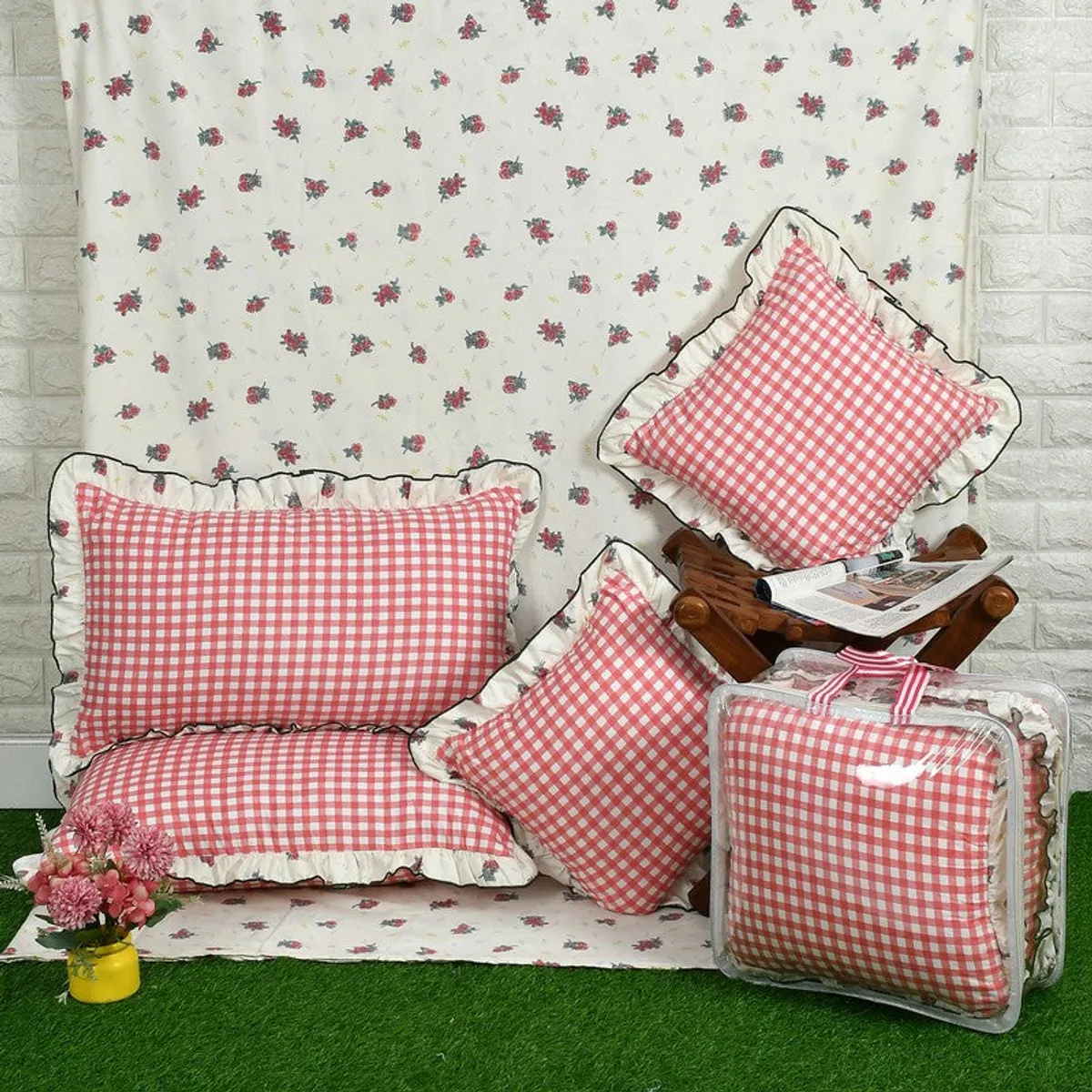 Bedding set display with floral bedsheet, pink checked covers and storage bag