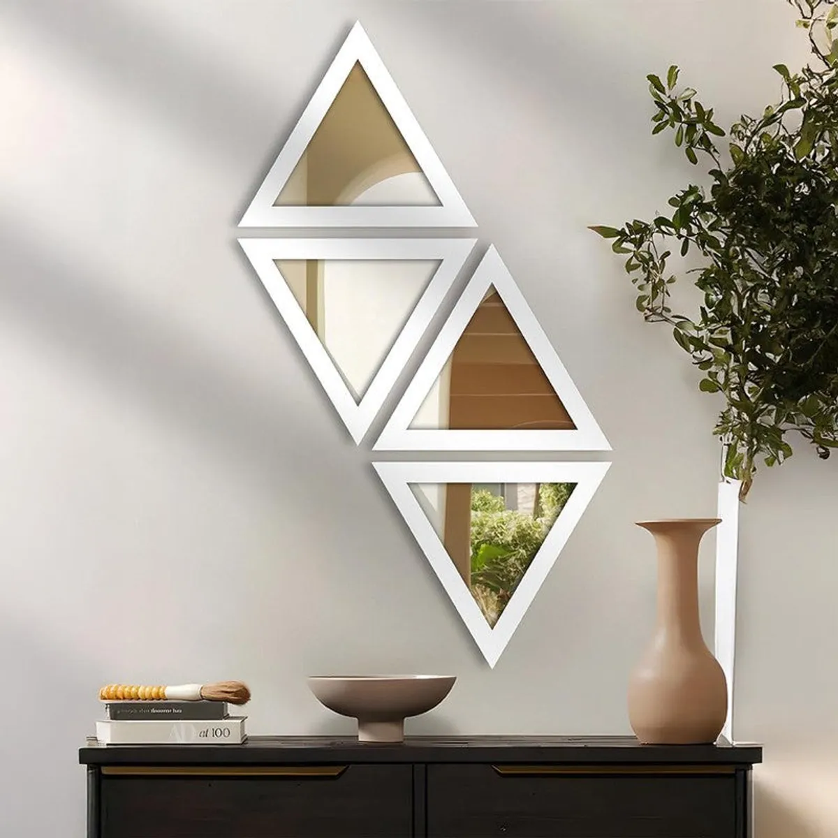 Four white triangular wall mirrors above a console table