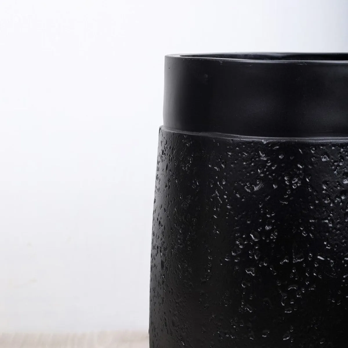 Close-up of the planter's textured black surface and smooth rim