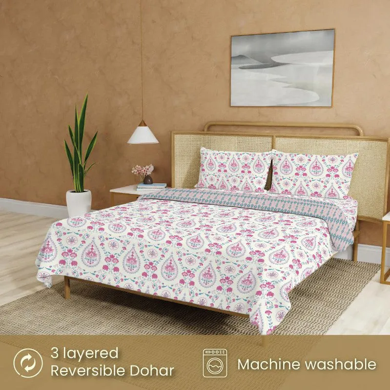 Bedding set styled on a bed with matching pillow covers and printed blanket