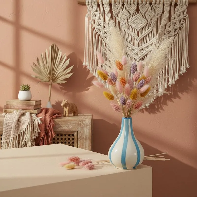 Striped ceramic vase styled with pastel dried stems in a boho interior