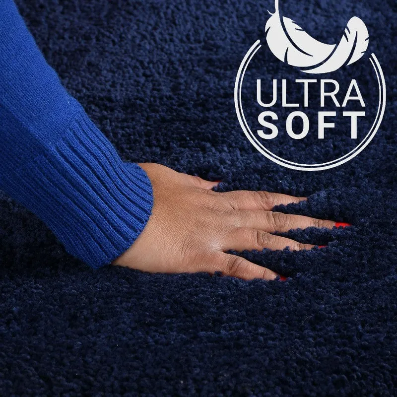 Close-up of a hand pressing into the soft dark blue bath mat