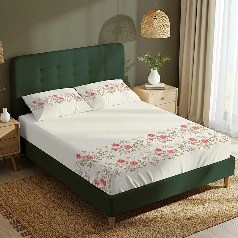 White floral bedsheet with matching pillow covers on a green bed