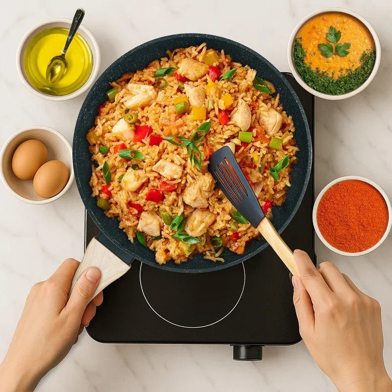 Frying pan filled with colourful rice and chicken on a cooktop