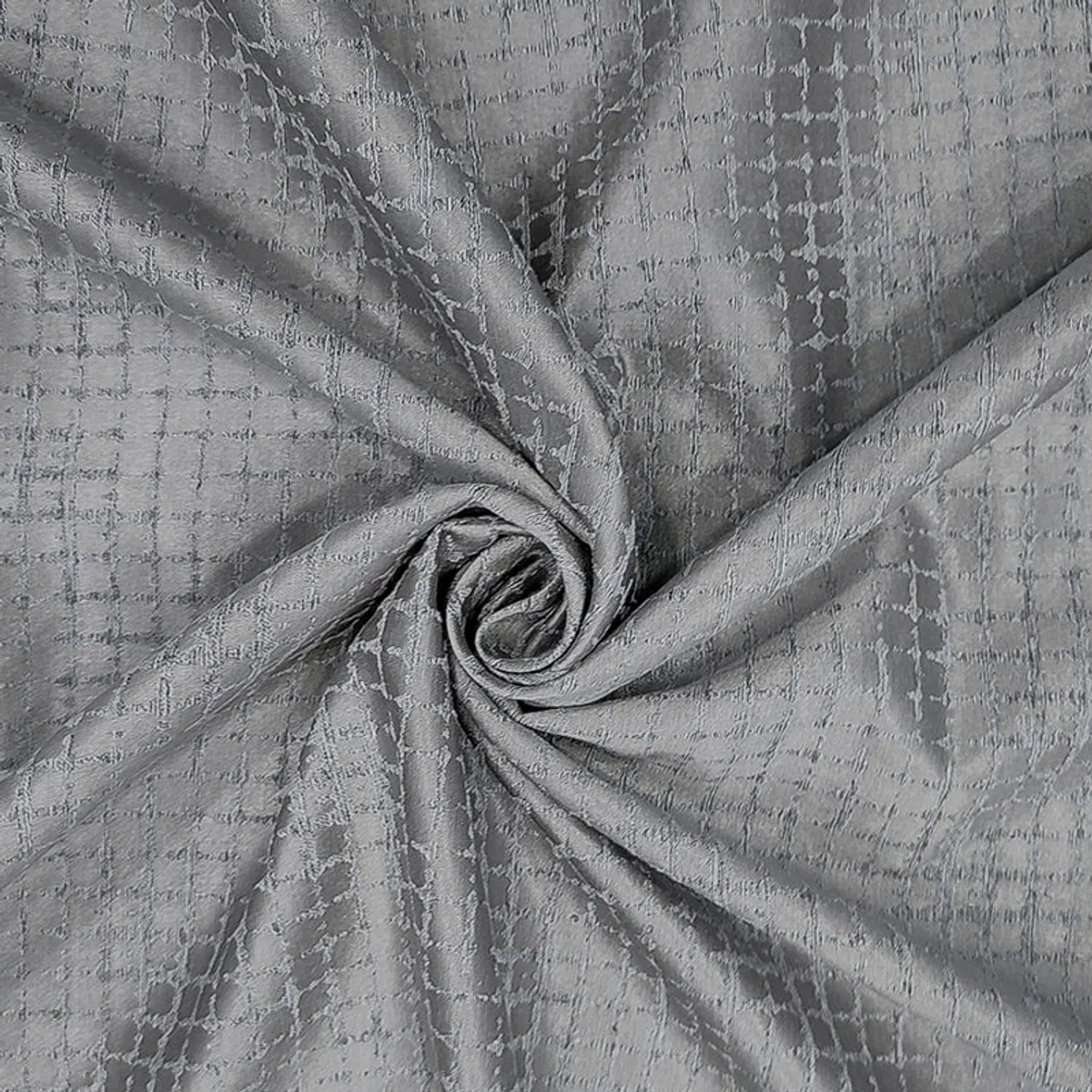 Grey jacquard curtain fabric gathered to show its smooth drape