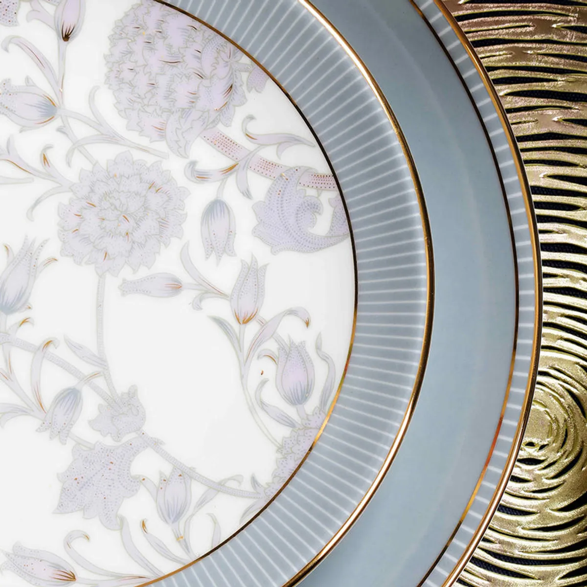 Close-up of floral porcelain plate with grey border, fine lines and gold rim
