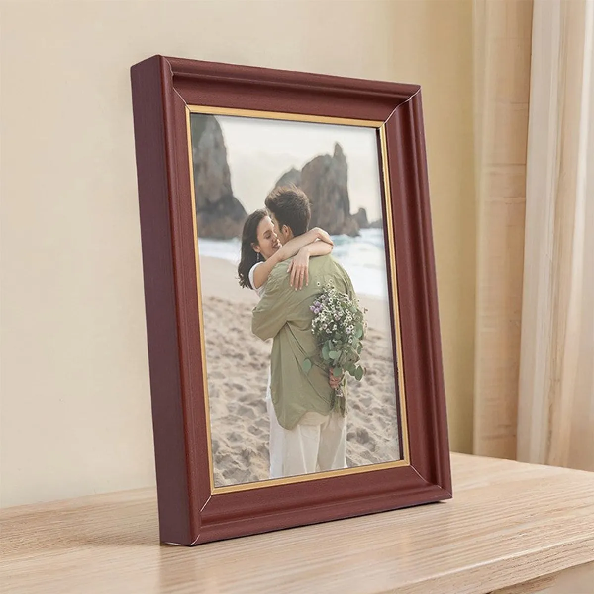 Brown tabletop photo frame with golden trim displayed on a wooden surface.