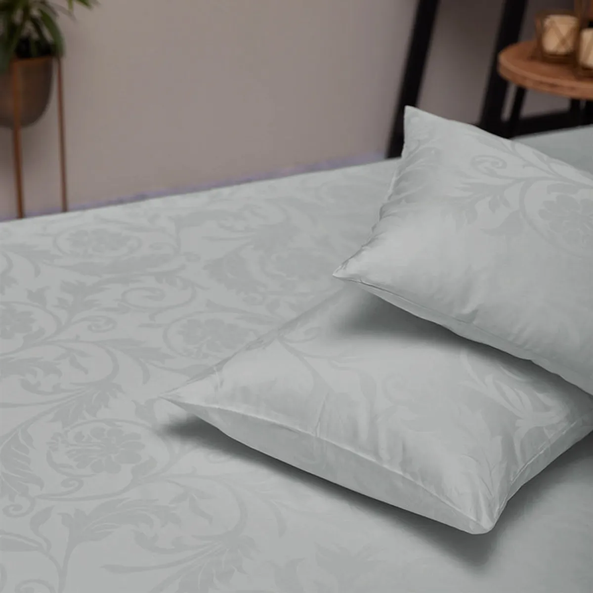 Light grey patterned duvet cover and pillows styled on a bedroom bed