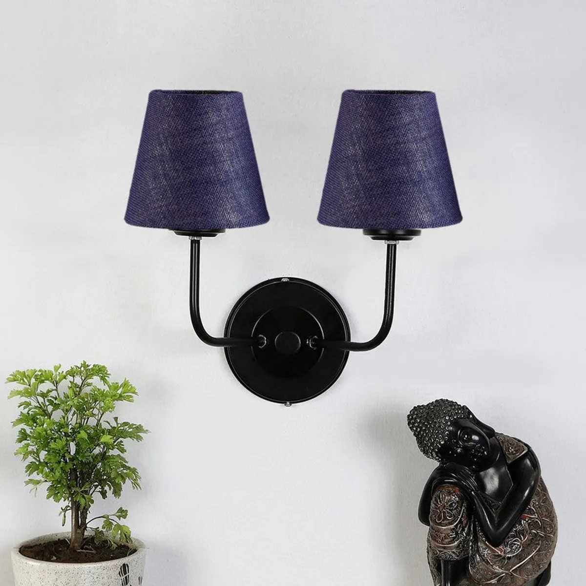 Blue jute twin wall lamp with black round base against a white wall