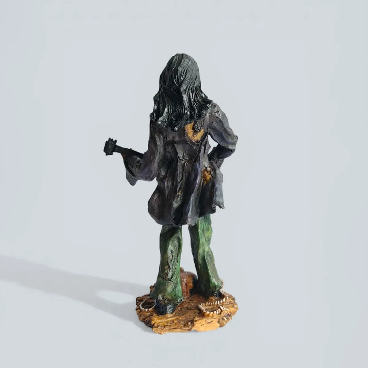 Back view of the zombie guitarist showpiece on a light grey background