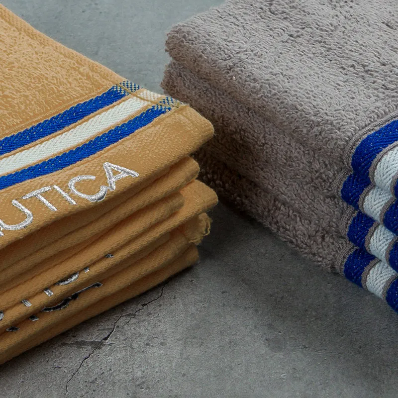 Close-up of plush beige and grey towels with striped borders