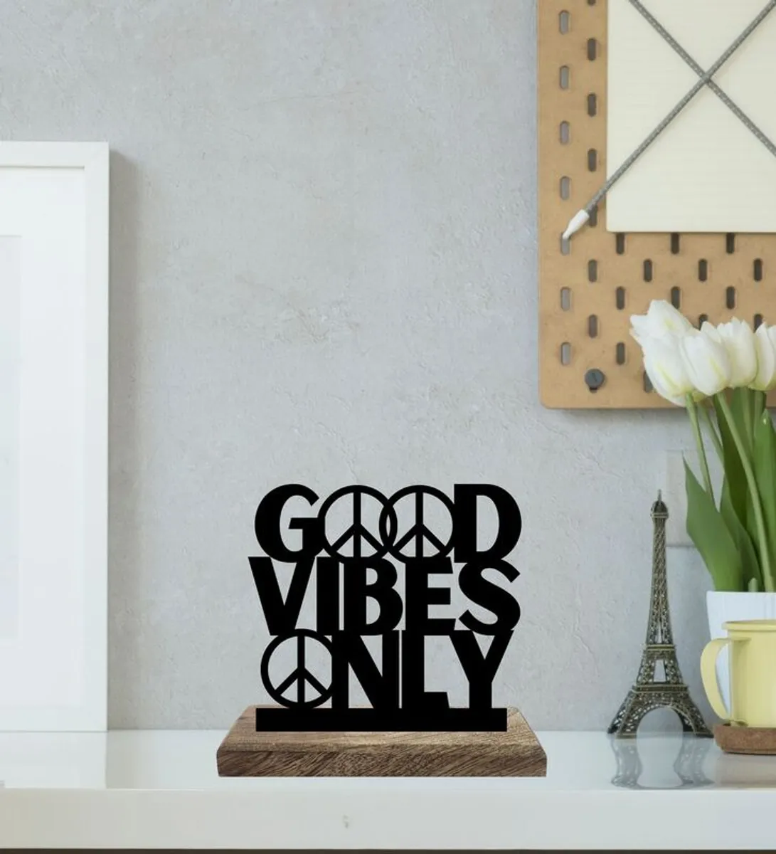 Black typography showpiece on a wooden base displayed on a white shelf