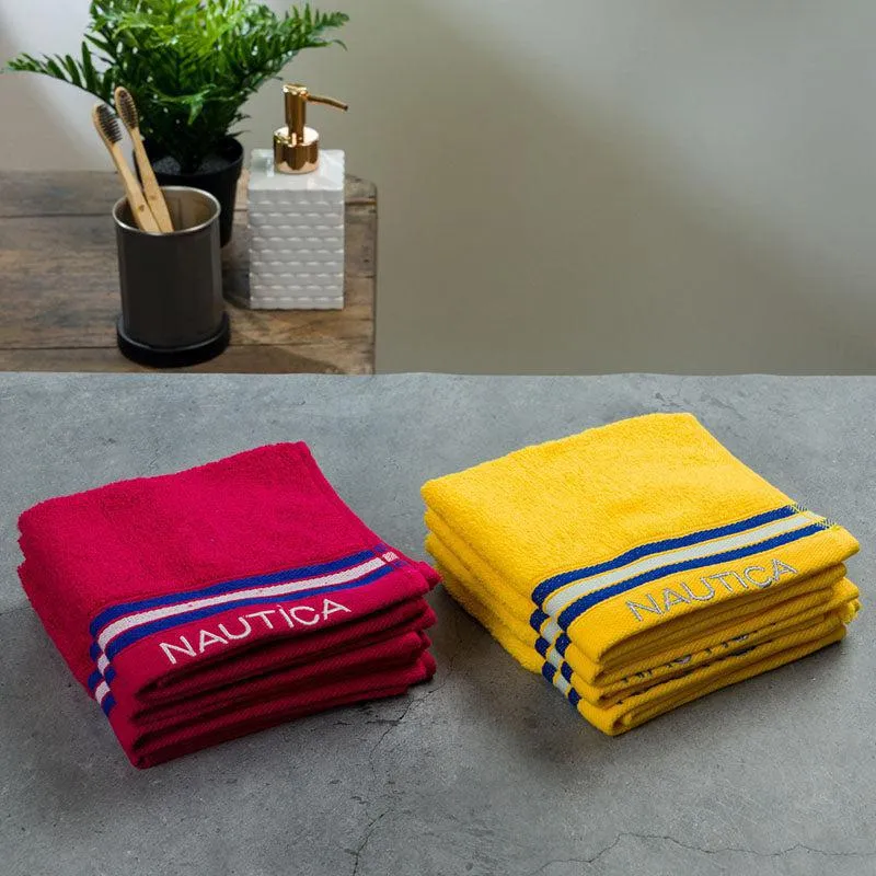 Stacks of burgundy and yellow face towels on a bathroom counter