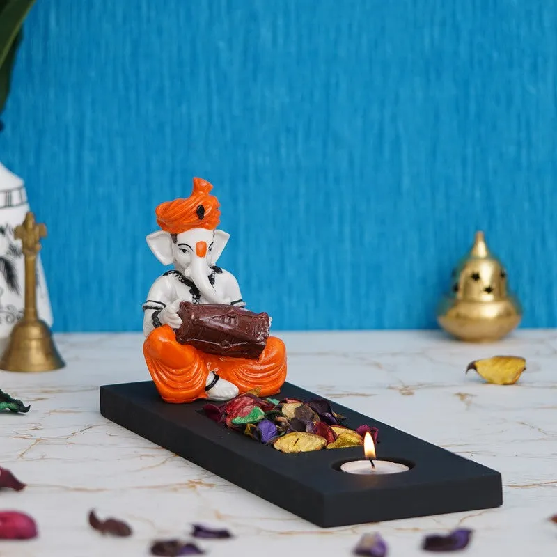 Ganesha tea light candle holder styled on a tabletop with a lit tea light