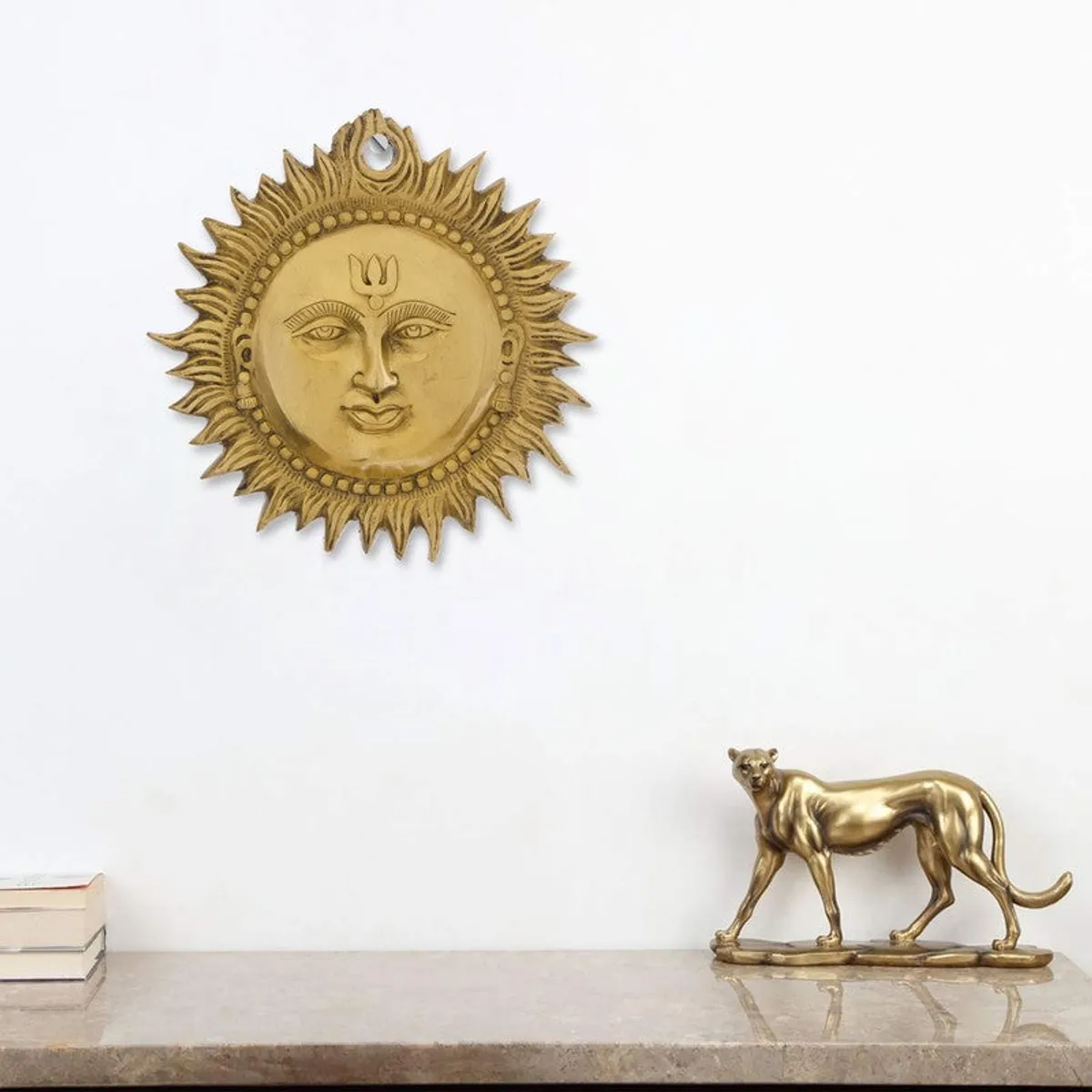 Gold round wall accent hung above a console in a styled room