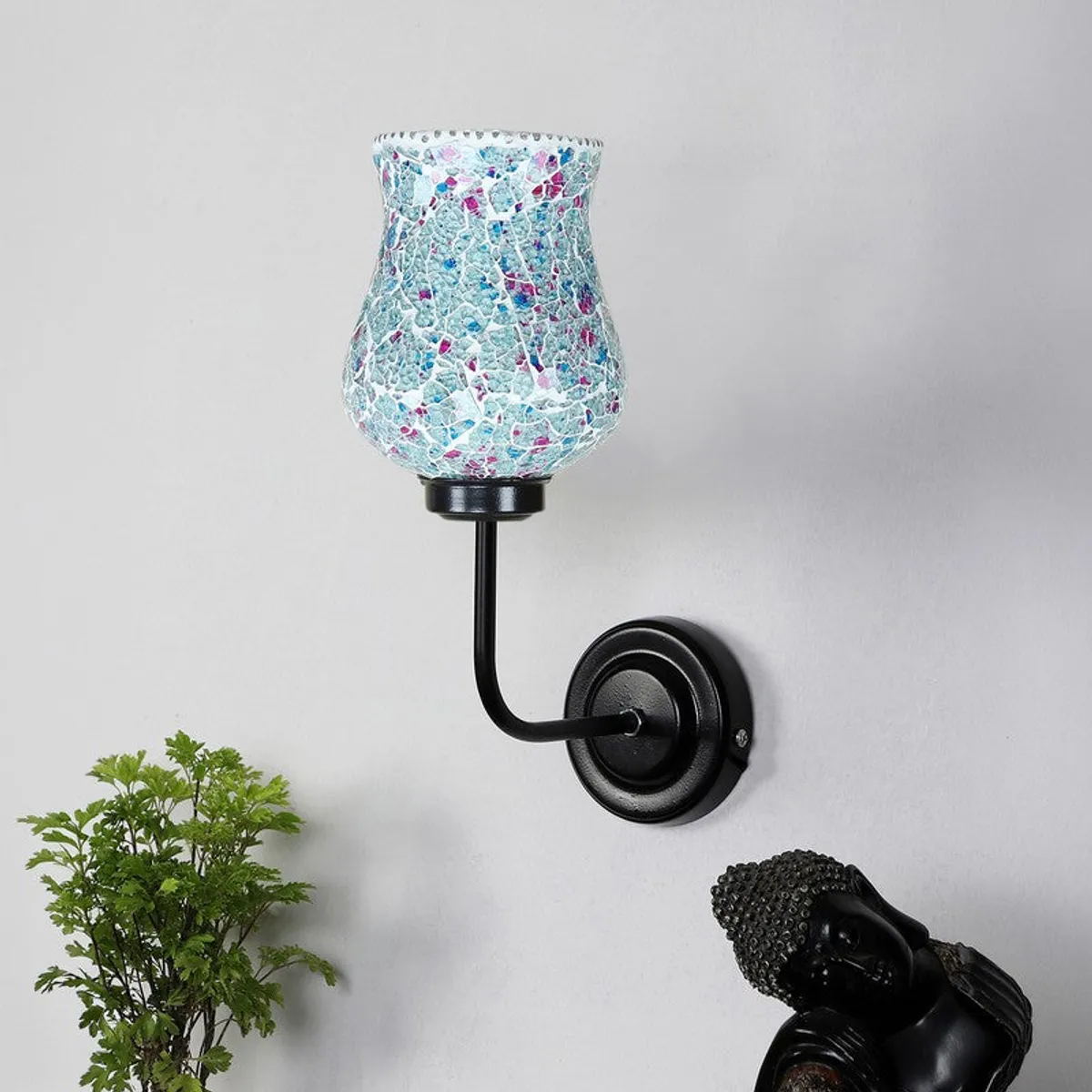 Close view of blue mosaic glass wall lamp with black iron base