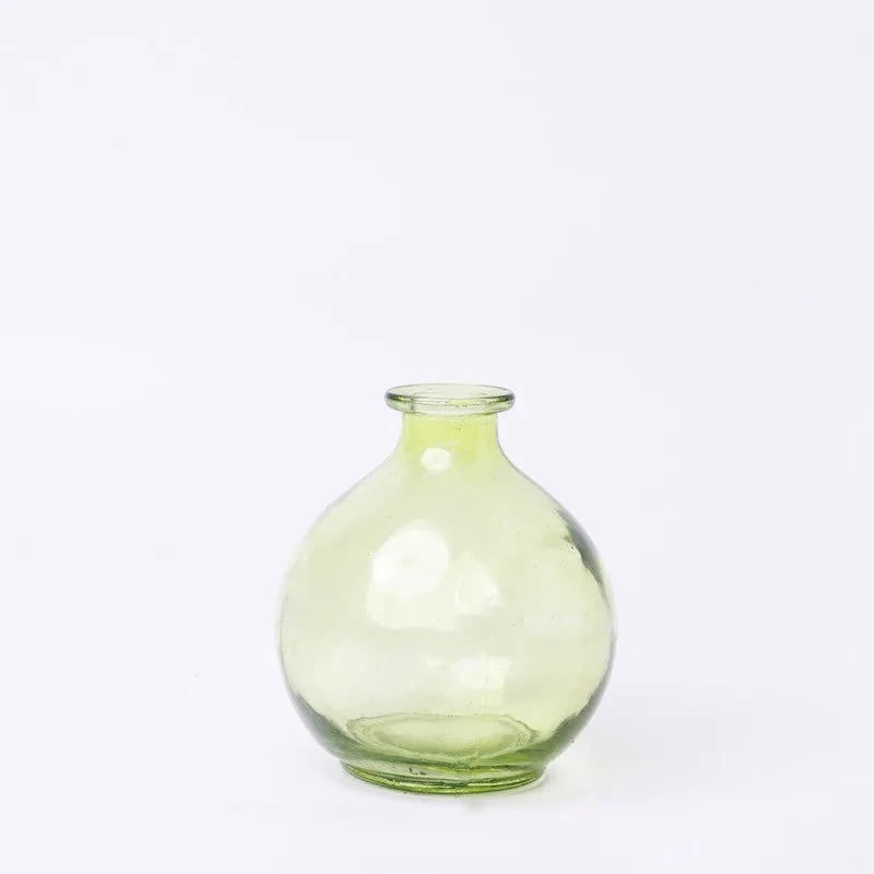 Empty round pale green glass vase on a white background