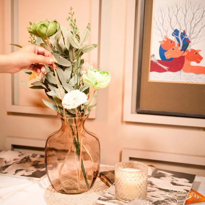Peach glass vase with dried flower bunch on a table