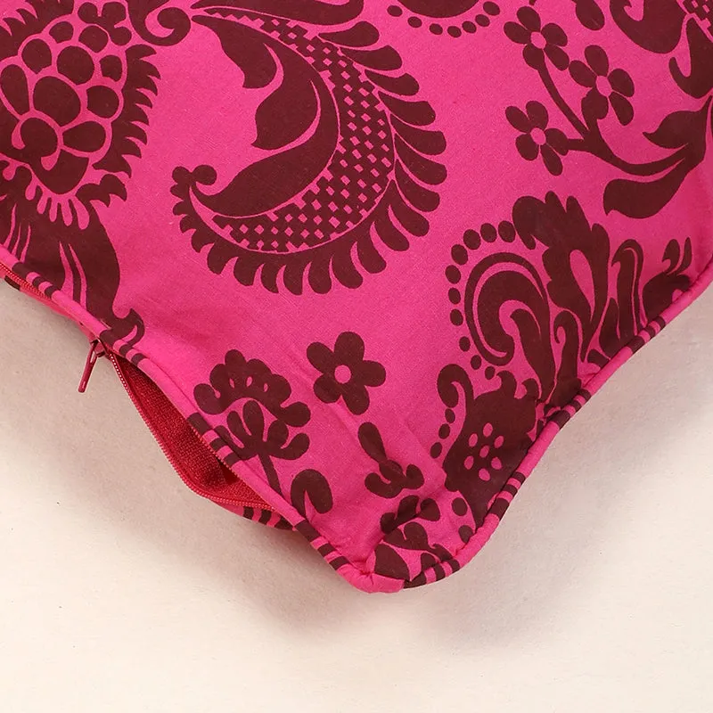 Close-up of pink cotton cushion cover fabric with brown floral details and a zip.