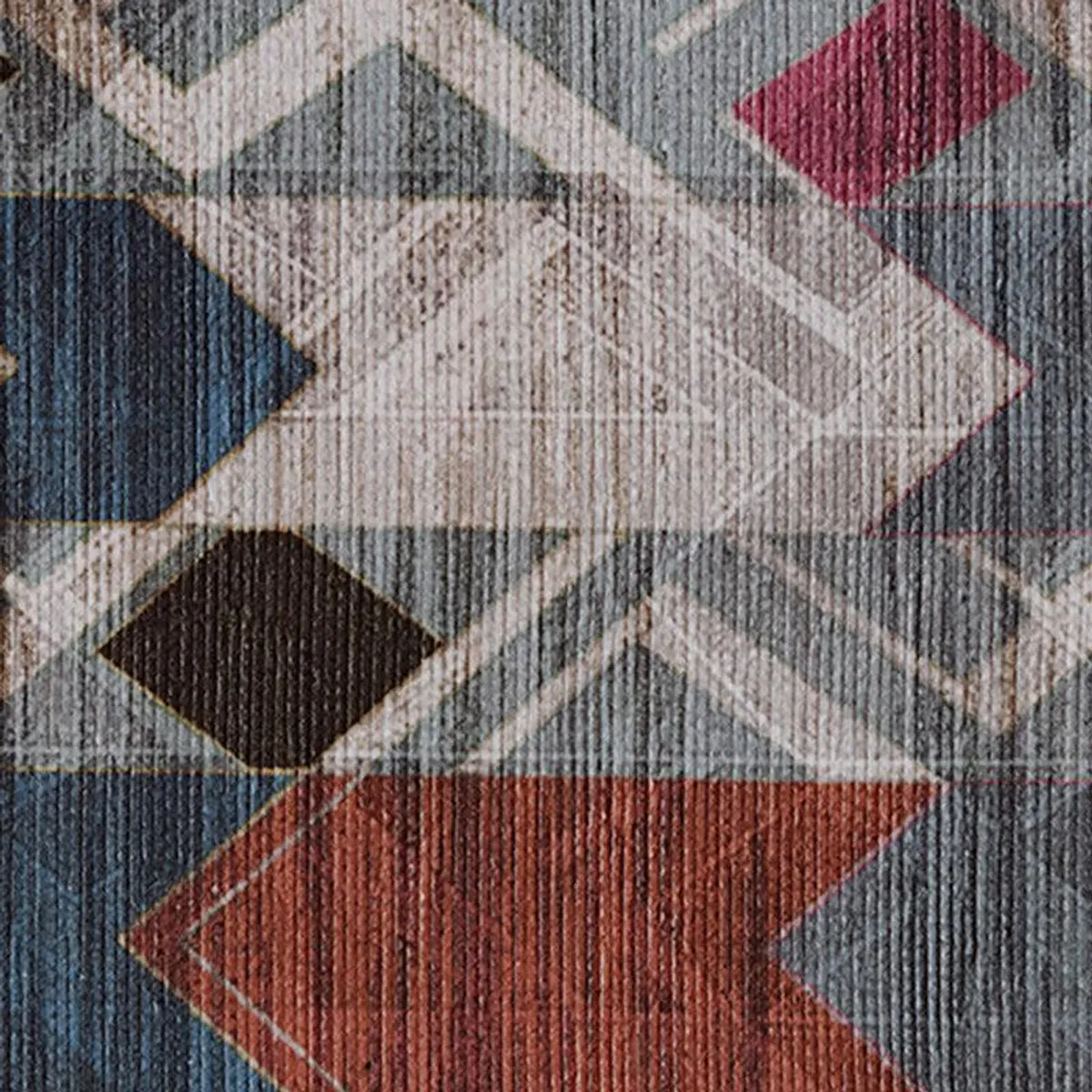 Close-up of the carpet surface with geometric motifs in grey, blue and red