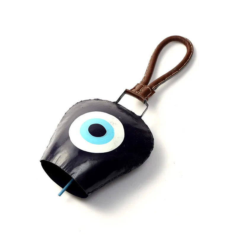 Black metal eye-motif bell shown at an angle with its leather loop