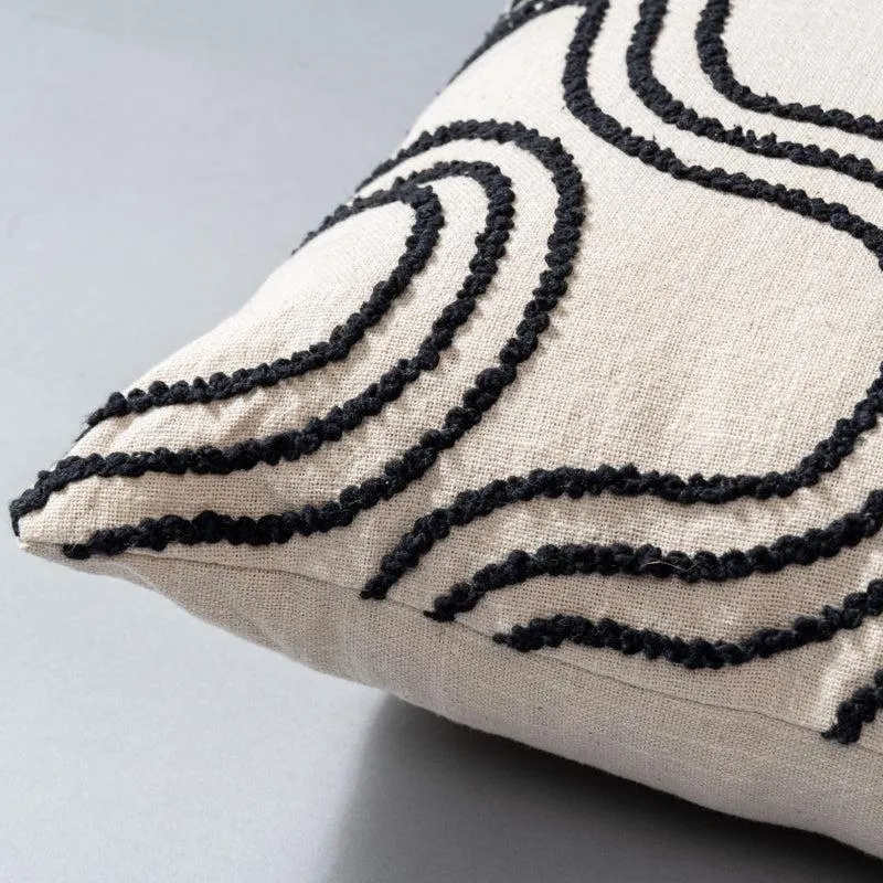 Close-up of ivory cushion cover with raised black abstract wave pattern