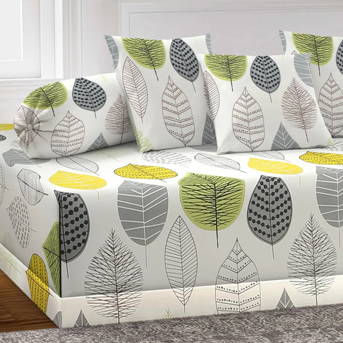 Close view of white diwan set with leaf print and matching cushions