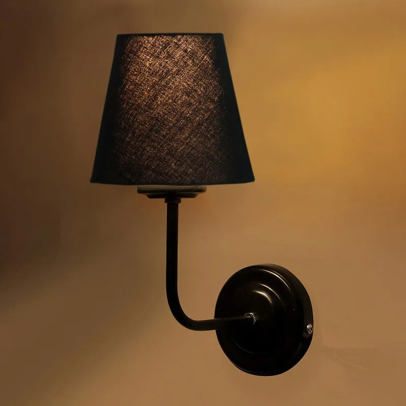 Close-up of black wall-mounted lamp with illuminated shade