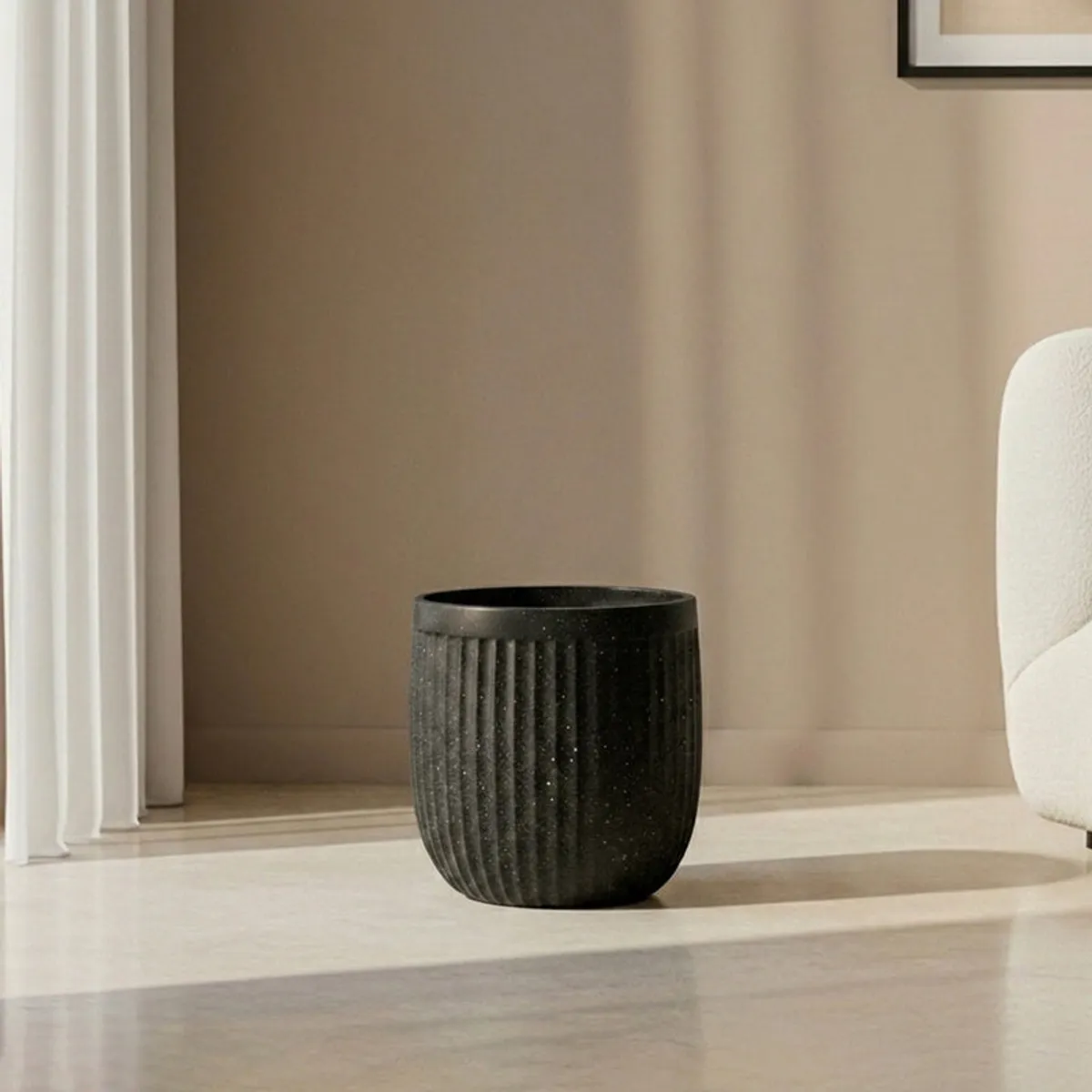 Small black ribbed planter displayed on a living room floor