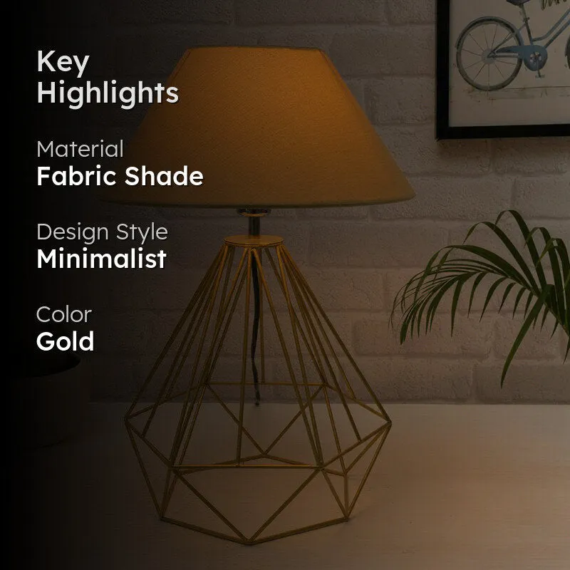 Gold table lamp in a dim styled setting with a fabric shade
