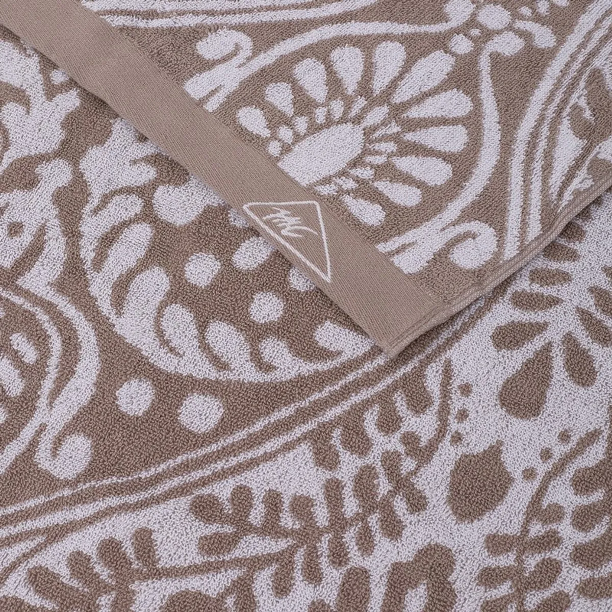 Close-up of beige floral towel border and soft terry texture