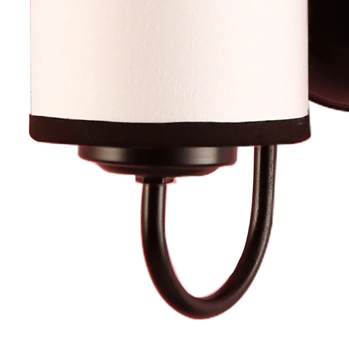 Close-up of the dark iron arm and lower fitting of the wall lamp