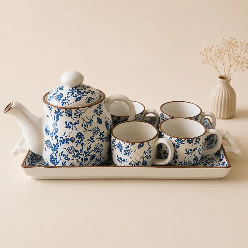Front view of blue and white floral ceramic teapot, cups and serving tray