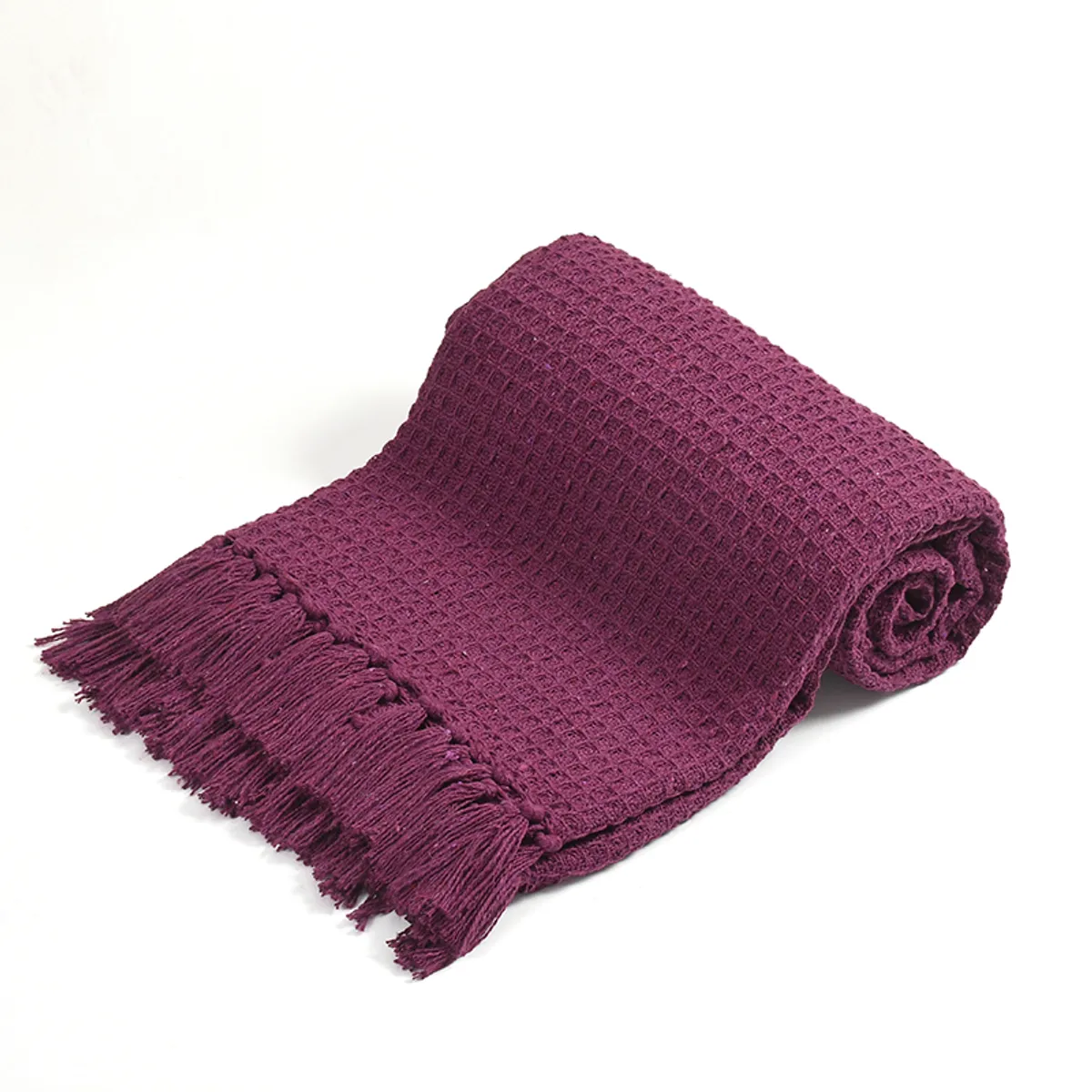 Rolled purple waffle throw with fringed edge on a white background