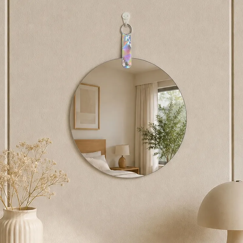 Small round frameless mirror hanging on a light textured wall