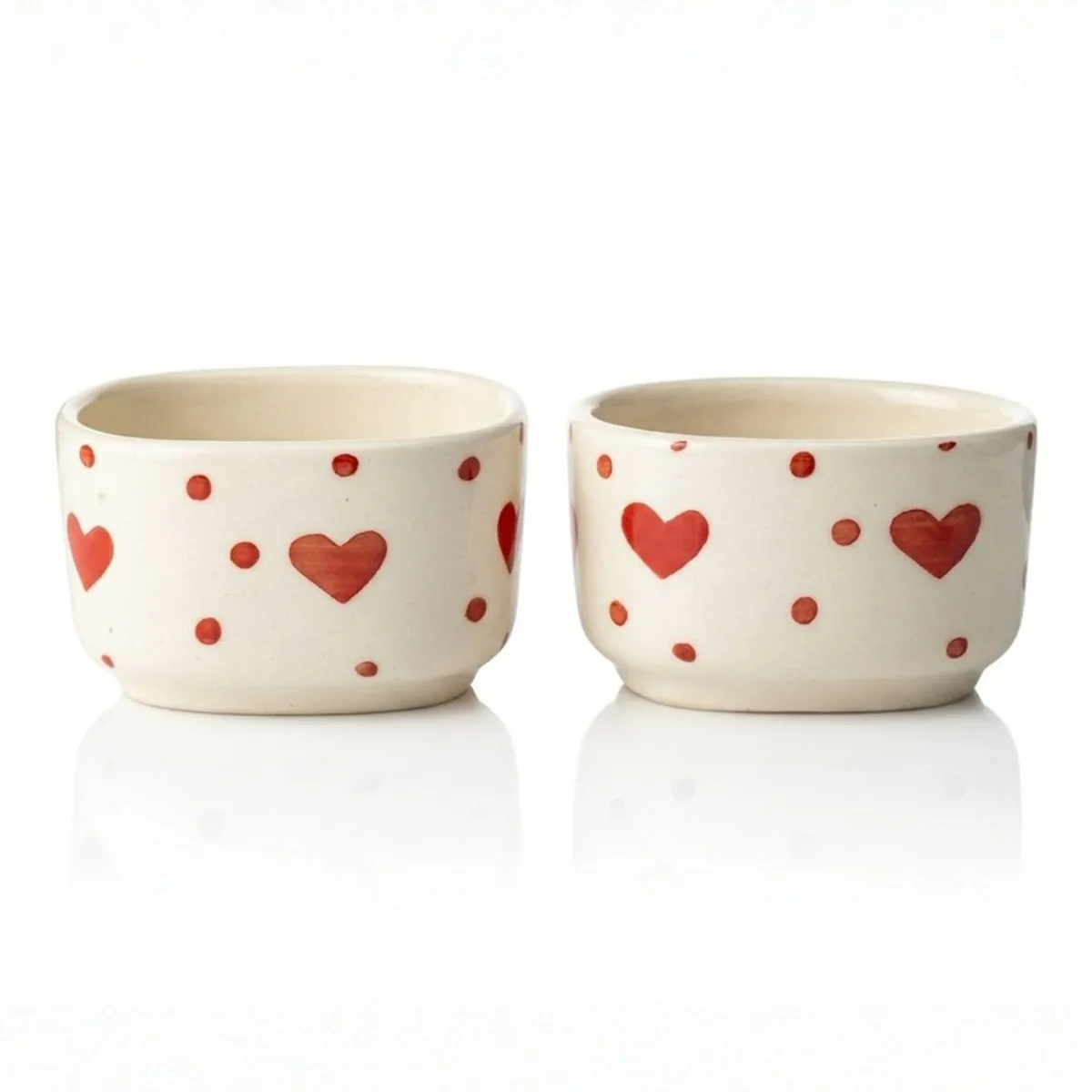 Front view of two white dip bowls with red heart and dot pattern