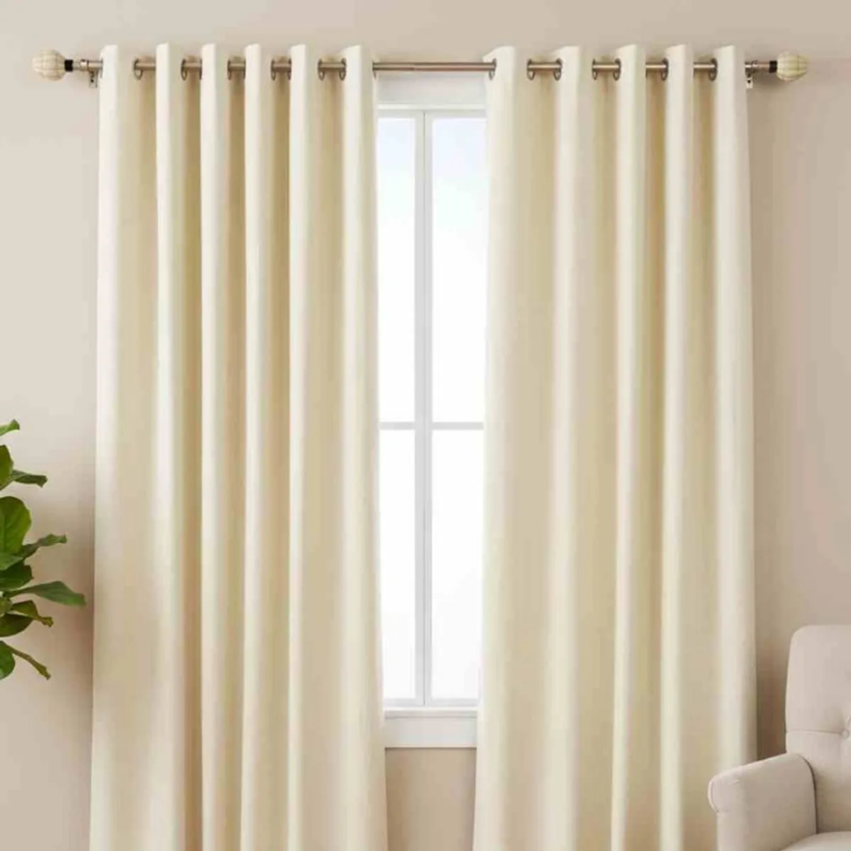 Extendable curtain rod with matching finials styled with cream eyelet curtains
