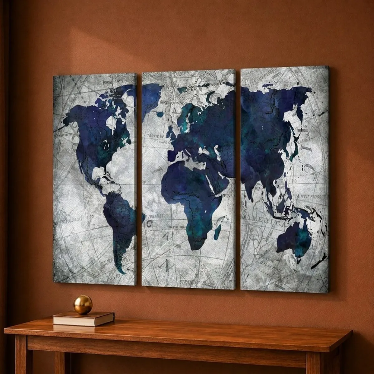 Three-panel world map canvas wall art in blue and grey on a brown wall