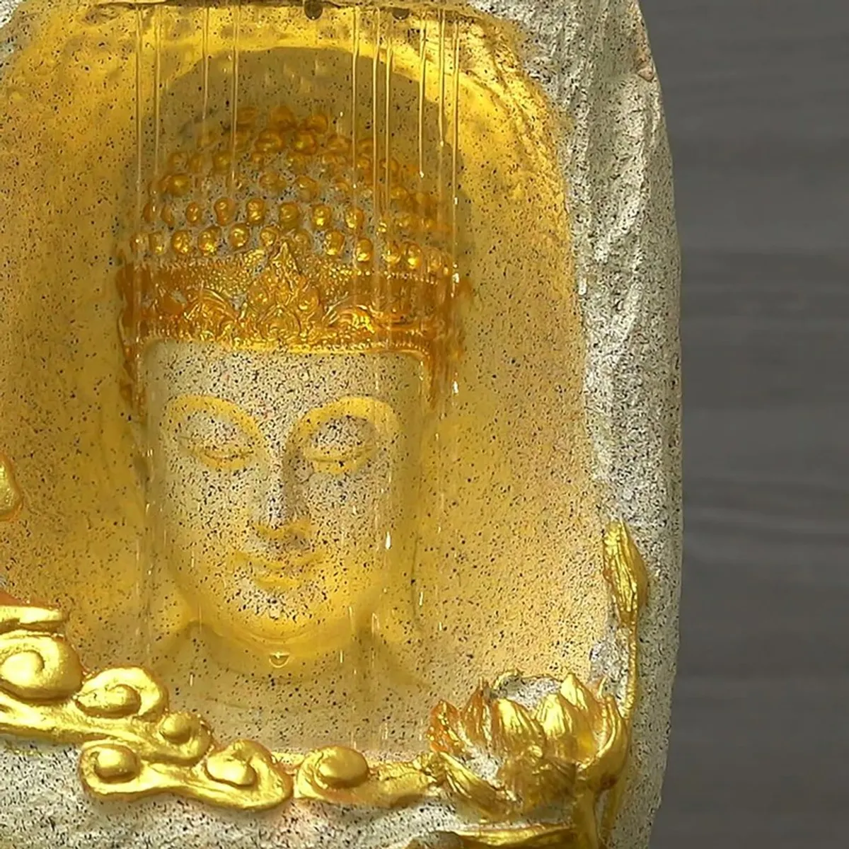 Close-up of the Buddha face and lotus detail with warm illumination