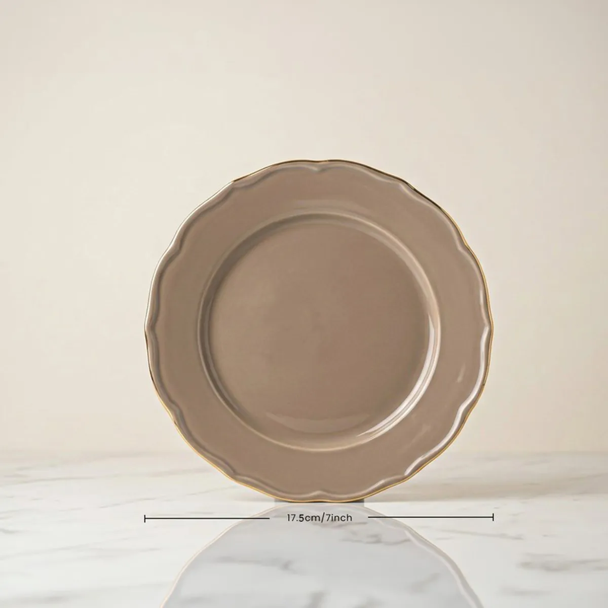 Single grey quarter plate with gold rim shown front on