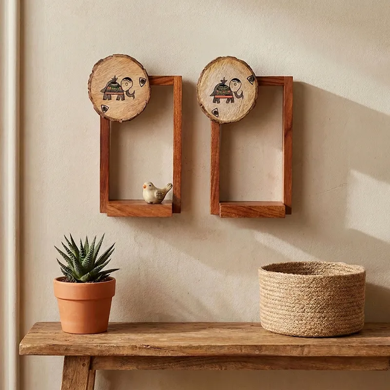 Pair of wooden elephant motif wall shelves styled above a console table