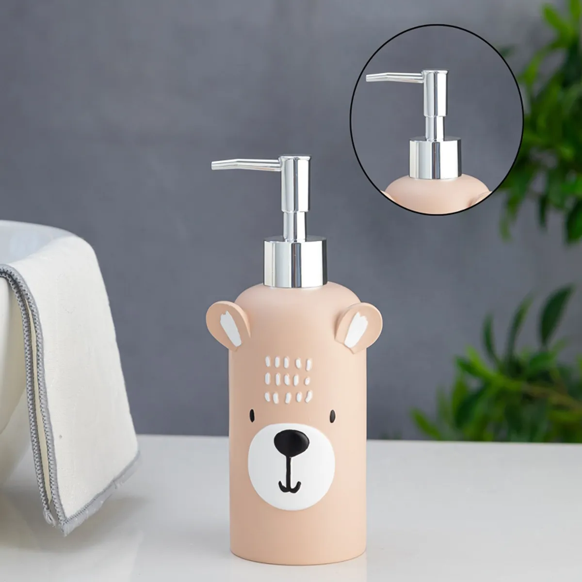 Peach kids soap dispenser with bear face and close-up of the silver pump
