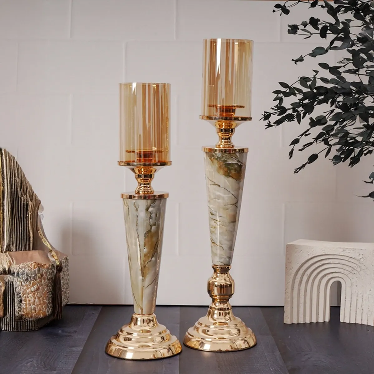 Pair of tall gold and white marble candle holders styled in a contemporary room
