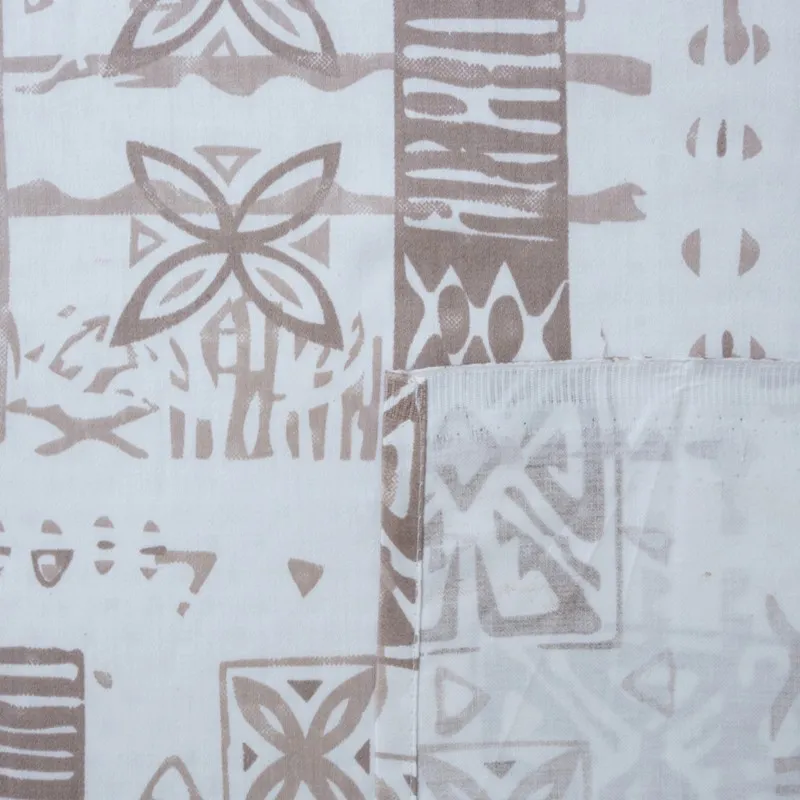 Close-up of white and brown printed bedsheet fabric with stitched edge detail