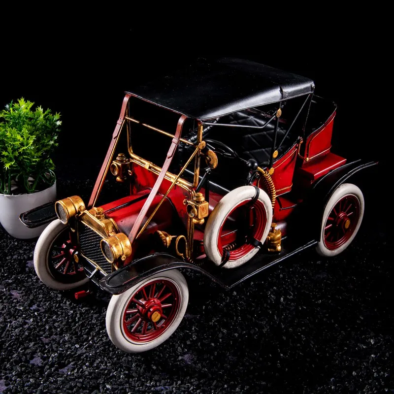 Top angled view of red vintage car showpiece with detailed wheels and black canopy
