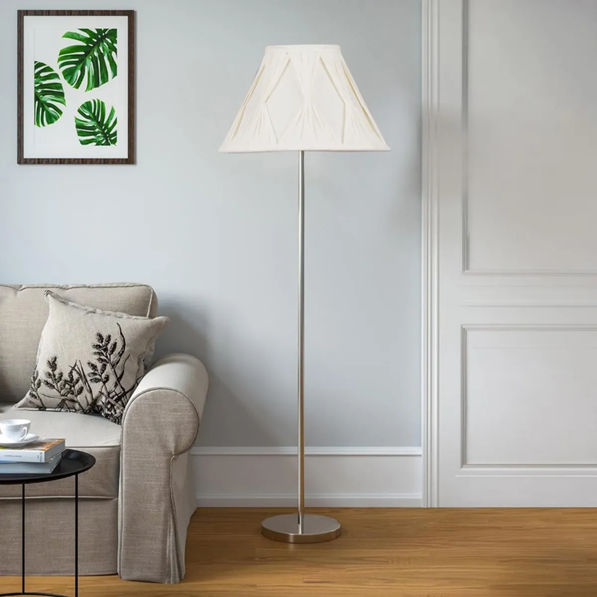 White tapered floor lamp with slim metal stand in a bright neutral room