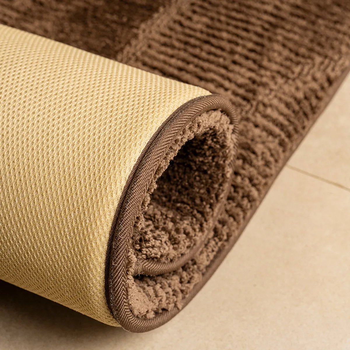 Rolled corner showing the textured surface and anti-skid backing of a brown runner