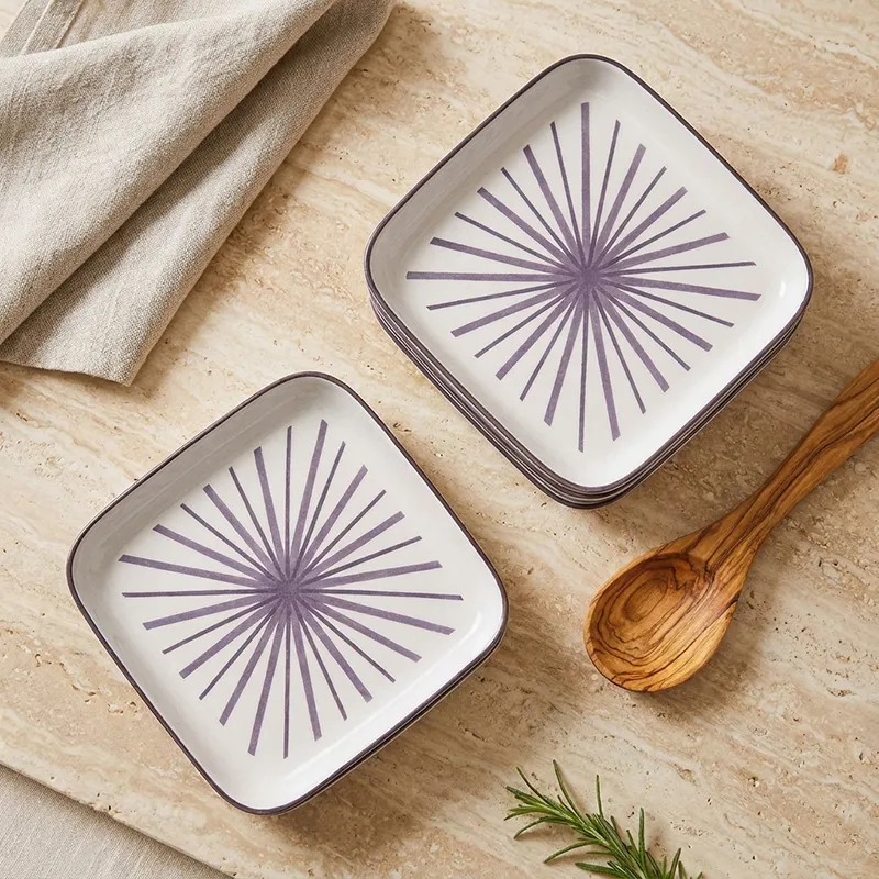 Top view of square white plates with purple sunburst pattern