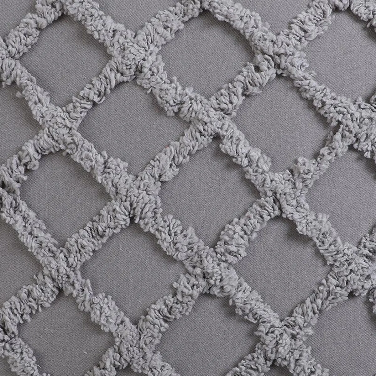 Detailed view of raised grey tufting forming a diamond pattern