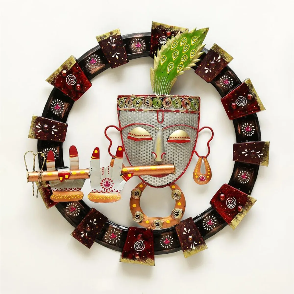 Round metal wall accent with a decorative face motif against a plain white background